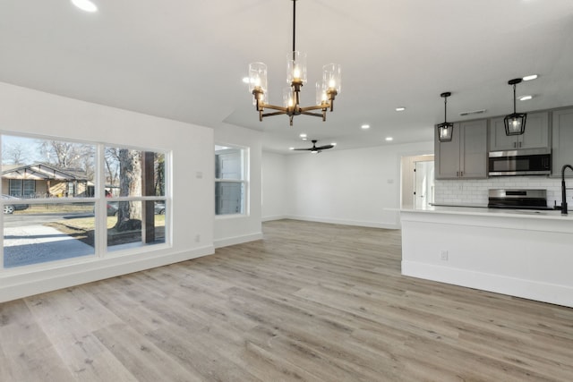 interior space featuring a notable chandelier, light wood-style flooring, and baseboards