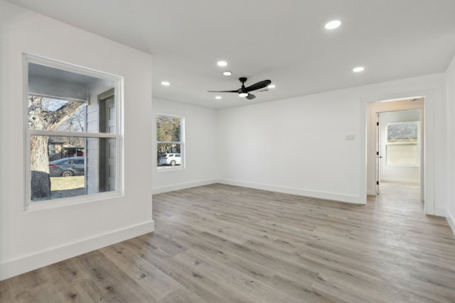 empty room with light wood-style floors, a wealth of natural light, baseboards, and recessed lighting