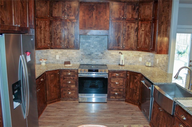 kitchen with light stone countertops, sink, appliances with stainless steel finishes, and tasteful backsplash