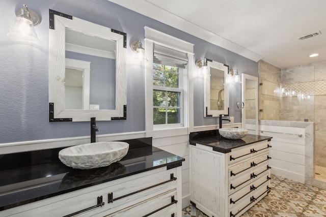 bathroom featuring tiled shower, vanity, and ornamental molding