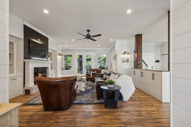 living room with french doors, hardwood / wood-style flooring, ceiling fan, built in shelves, and ornamental molding