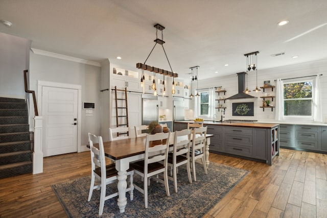 dining room with wood-type flooring and crown molding