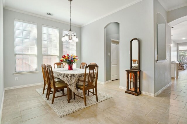 tiled dining room featuring crown molding and a chandelier