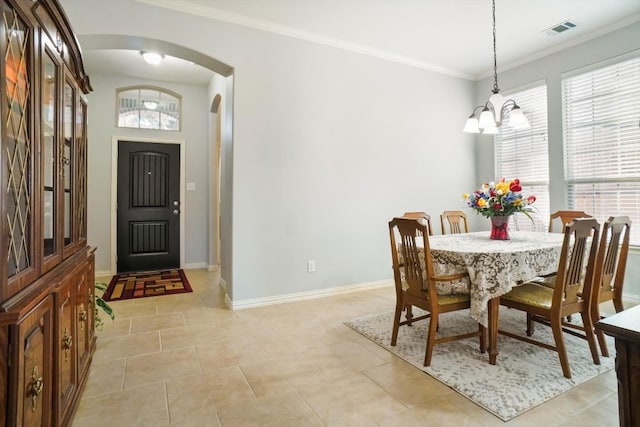 dining room featuring light tile patterned floors, crown molding, a wealth of natural light, and an inviting chandelier