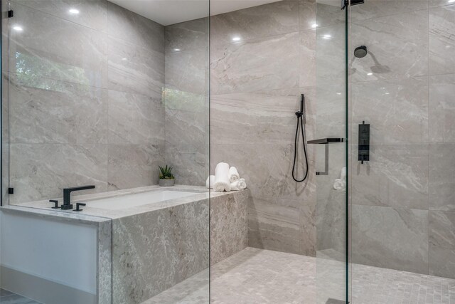 bathroom with tile walls and tiled shower