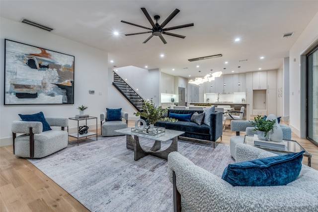 living room with ceiling fan and light wood-type flooring