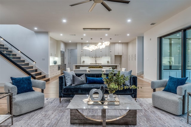 living room with ceiling fan and light wood-type flooring