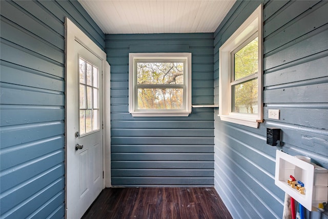 entryway featuring dark hardwood / wood-style flooring and wooden walls