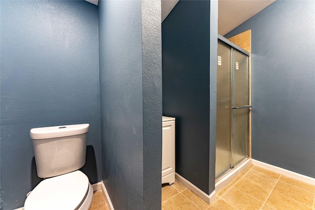 bathroom featuring tile patterned floors, toilet, and an enclosed shower