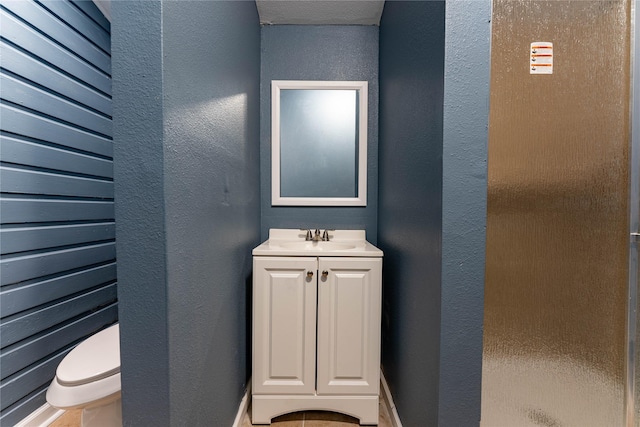 bathroom featuring a shower, vanity, and toilet