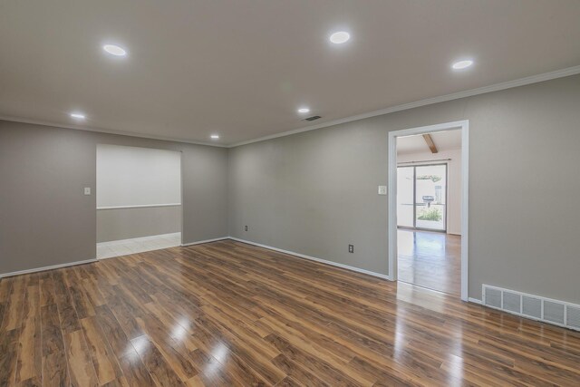 empty room featuring dark hardwood / wood-style floors and crown molding