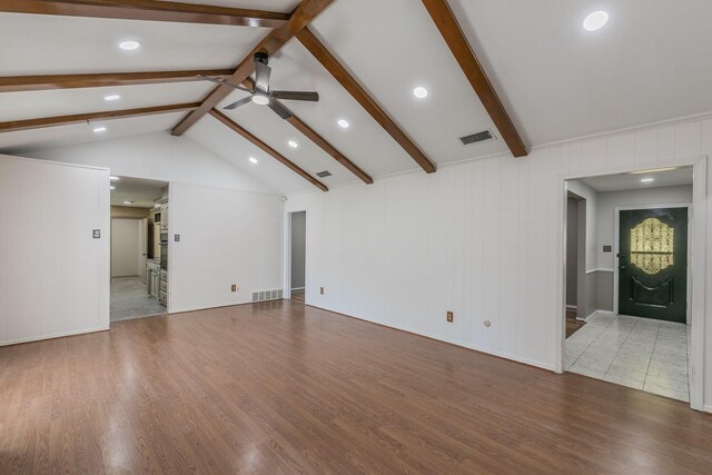 unfurnished living room featuring hardwood / wood-style flooring, lofted ceiling with beams, and ceiling fan