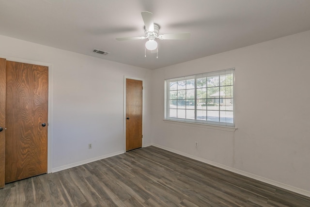 spare room with dark hardwood / wood-style flooring and ceiling fan