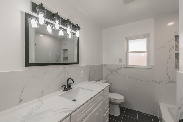 bathroom with tile patterned floors, vanity, toilet, and tile walls