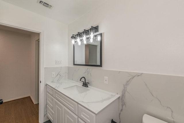 bathroom with vanity, hardwood / wood-style flooring, and toilet