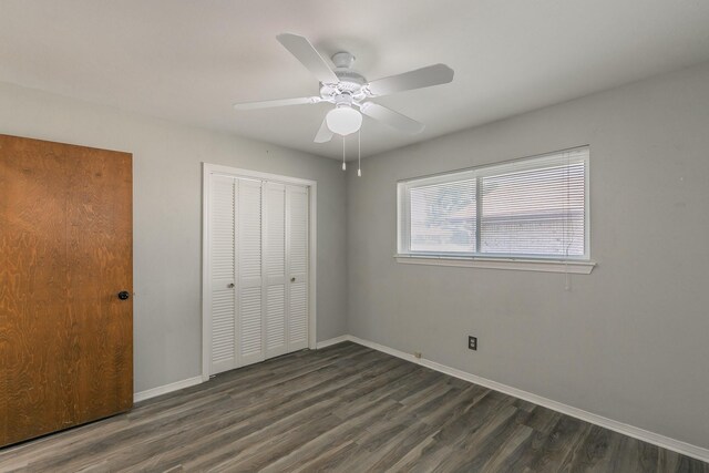 unfurnished bedroom featuring a closet, ceiling fan, and dark hardwood / wood-style flooring