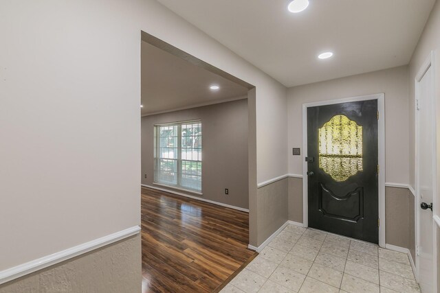 foyer entrance featuring light hardwood / wood-style floors and crown molding