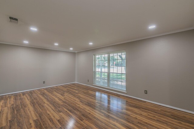 unfurnished room with ornamental molding and dark wood-type flooring