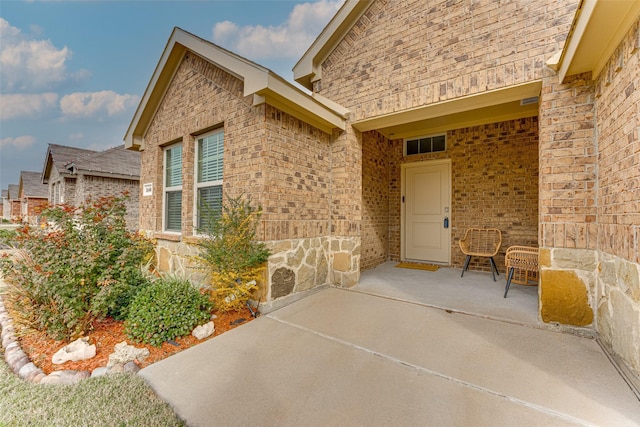 view of exterior entry featuring a patio area