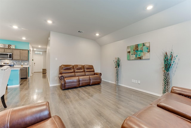 living room featuring light hardwood / wood-style flooring and lofted ceiling