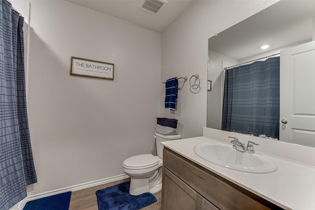 bathroom with a shower with shower curtain, vanity, wood-type flooring, and toilet