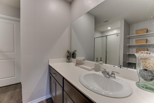 bathroom featuring hardwood / wood-style floors, vanity, and an enclosed shower