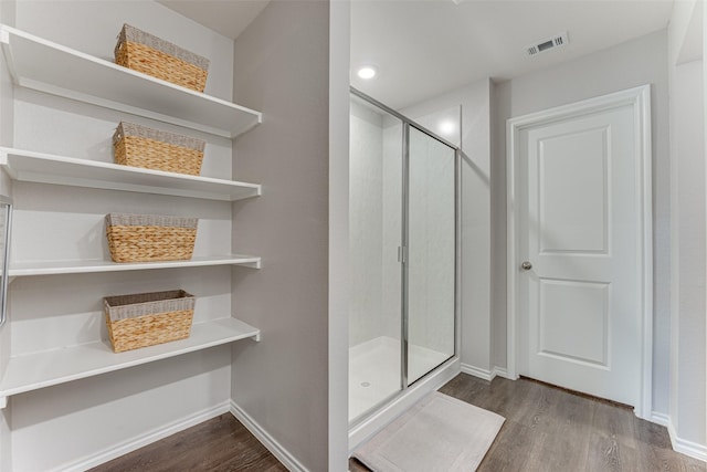 bathroom featuring a shower with door and hardwood / wood-style flooring