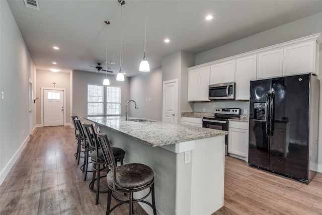 kitchen with white cabinets, sink, an island with sink, and appliances with stainless steel finishes