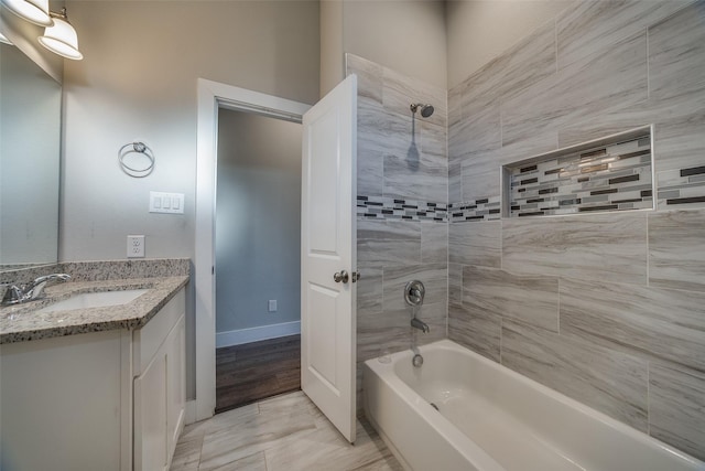 bathroom with vanity, hardwood / wood-style floors, and tiled shower / bath combo