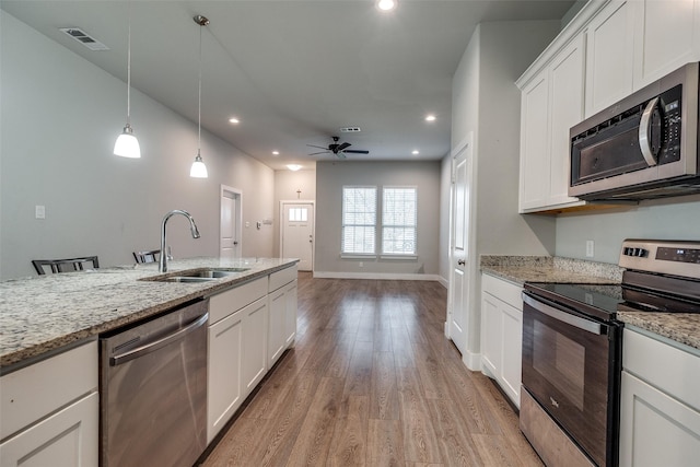 kitchen with white cabinetry, light hardwood / wood-style flooring, stainless steel appliances, and light stone counters