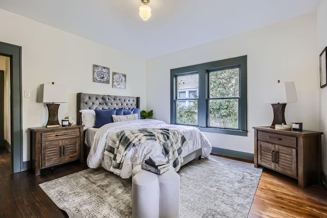 bedroom with dark hardwood / wood-style floors