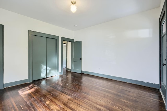 unfurnished bedroom featuring dark hardwood / wood-style flooring and a closet