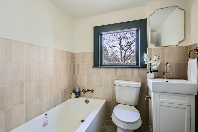 bathroom with a washtub, tile patterned flooring, toilet, vanity, and tile walls