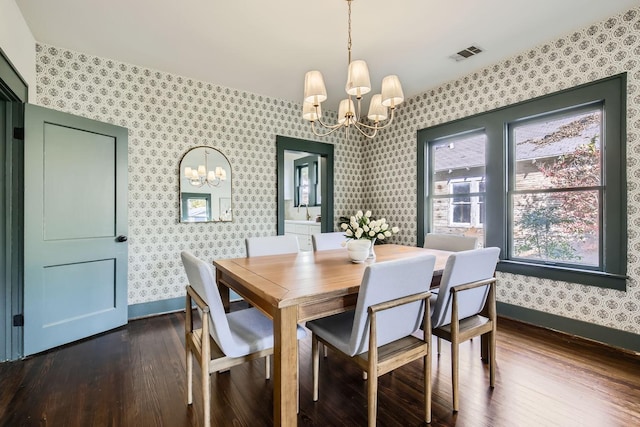 dining area featuring dark hardwood / wood-style floors and a chandelier