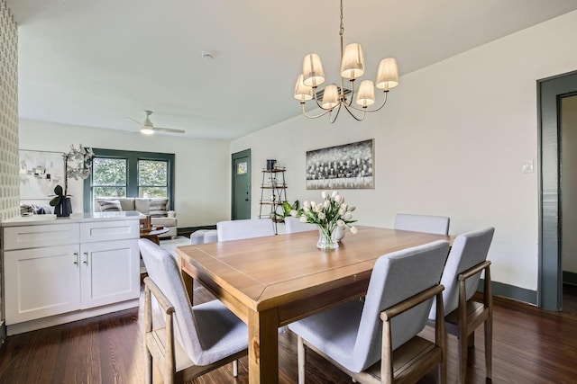 dining area with ceiling fan with notable chandelier and dark wood-type flooring