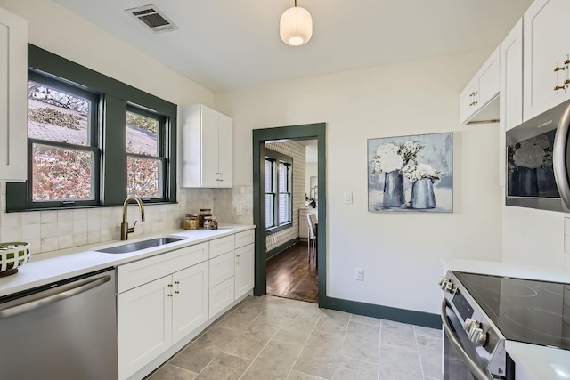 kitchen with white cabinetry, sink, and stainless steel appliances