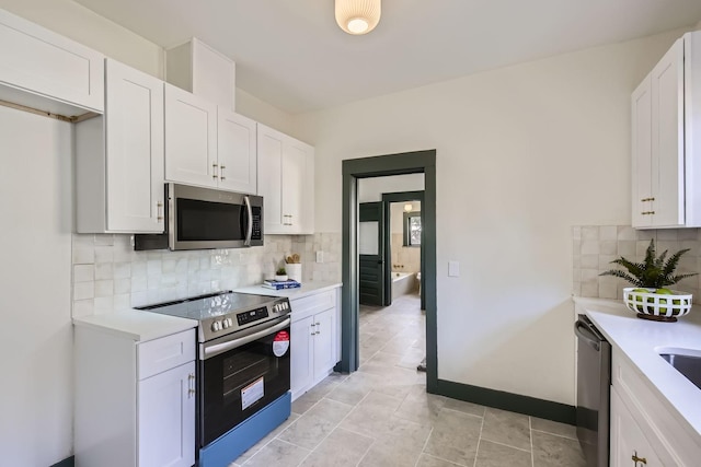 kitchen featuring decorative backsplash, white cabinetry, and appliances with stainless steel finishes