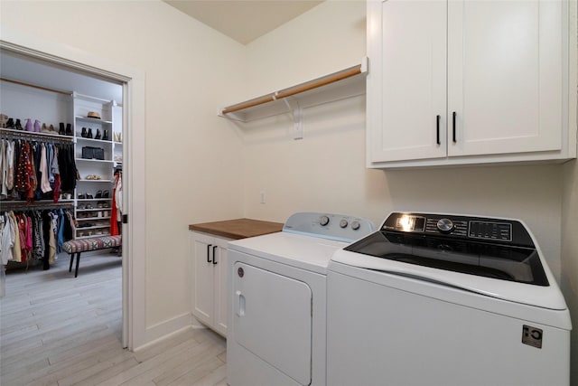 washroom with light hardwood / wood-style floors, cabinets, and independent washer and dryer