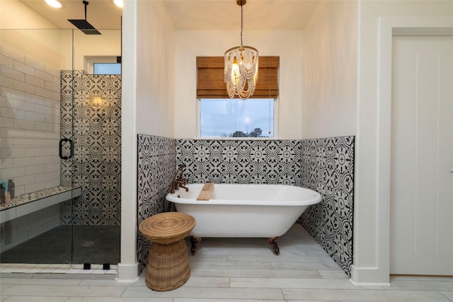 bathroom featuring hardwood / wood-style floors, tile walls, independent shower and bath, and an inviting chandelier