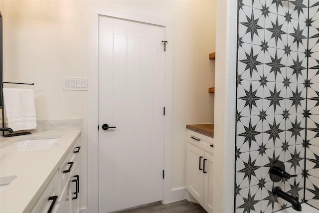 bathroom featuring a shower, hardwood / wood-style floors, and vanity