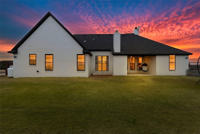 back house at dusk with a yard