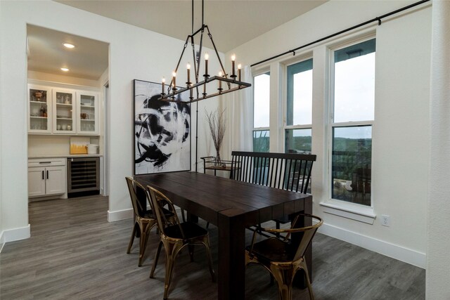 dining space with a chandelier, dark hardwood / wood-style flooring, and beverage cooler