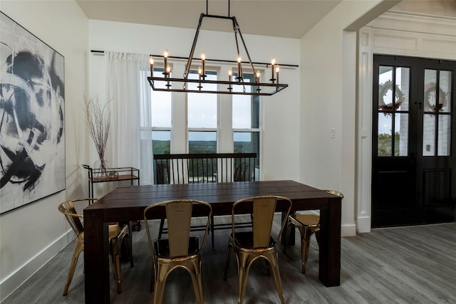 dining space with hardwood / wood-style flooring, plenty of natural light, an inviting chandelier, and french doors