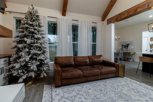 living room featuring a notable chandelier, light hardwood / wood-style floors, and lofted ceiling with beams