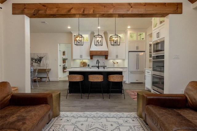 kitchen featuring pendant lighting, stainless steel microwave, high end fridge, and beam ceiling