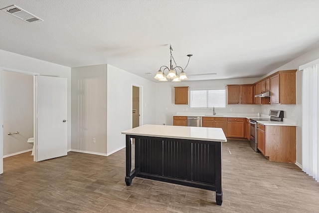 kitchen with sink, a center island, hanging light fixtures, a notable chandelier, and appliances with stainless steel finishes