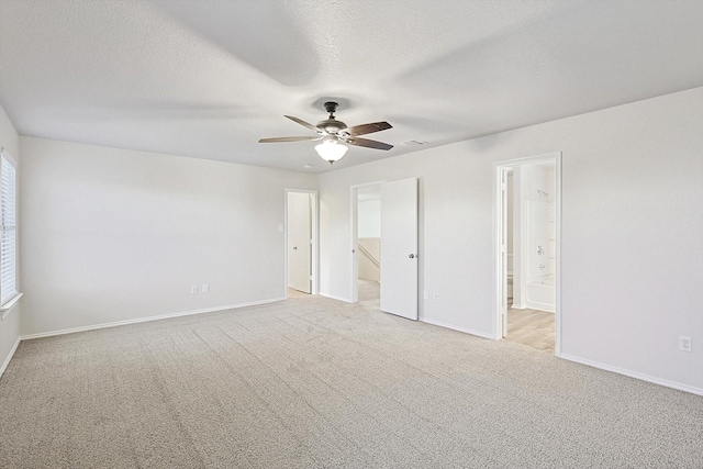 carpeted empty room featuring ceiling fan and a textured ceiling