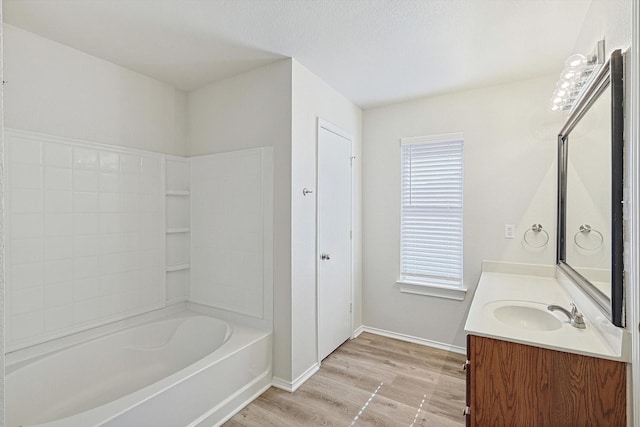 bathroom with hardwood / wood-style floors, vanity, and washtub / shower combination