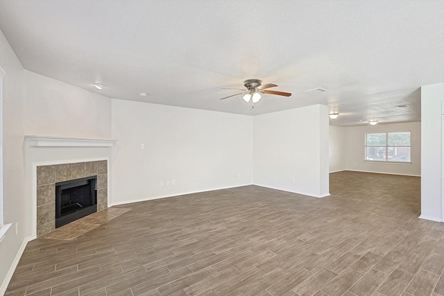 unfurnished living room with ceiling fan, a fireplace, and dark hardwood / wood-style floors