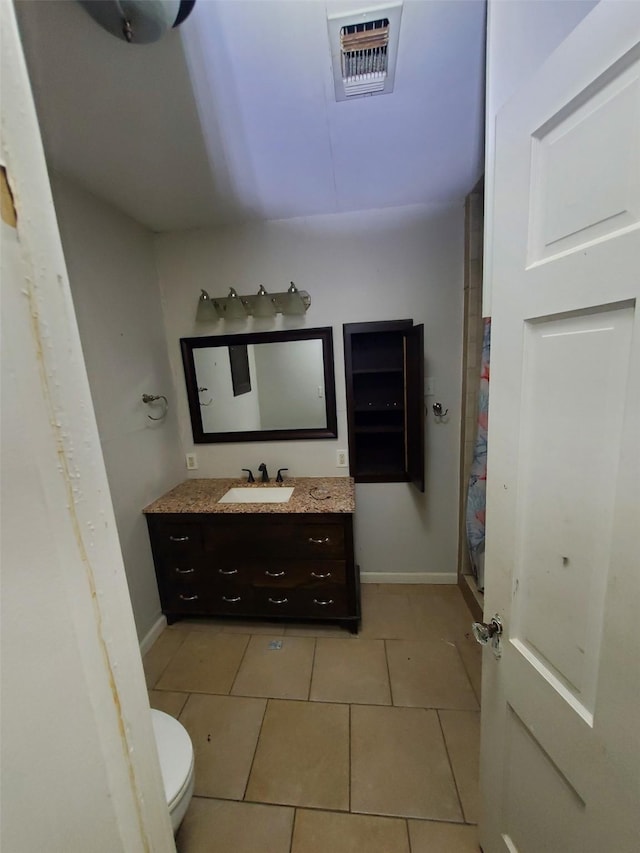 bathroom with tile patterned flooring, vanity, and toilet